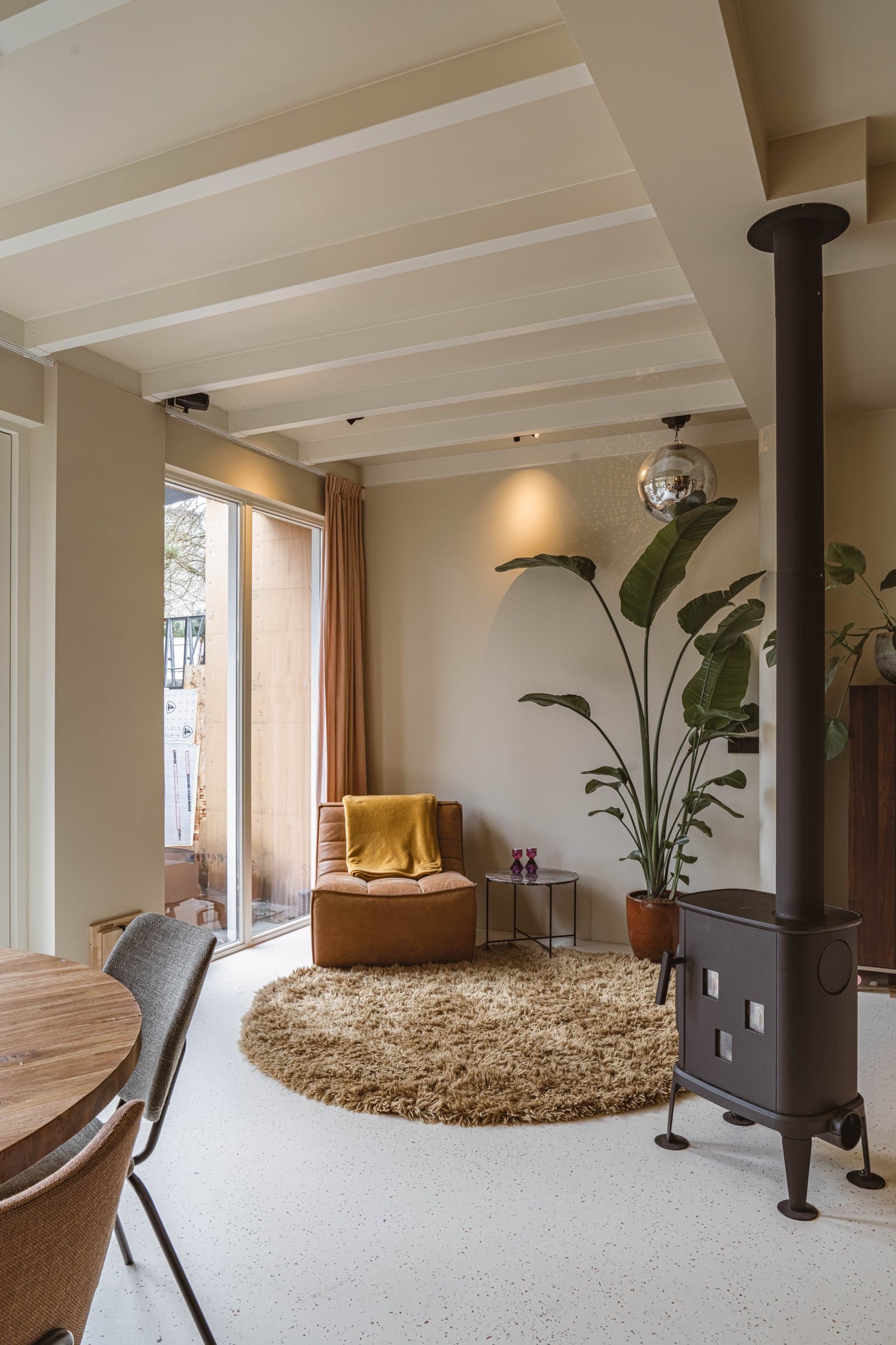 Woonkamer met houtkachel en wit balkenplafond, Amsterdam