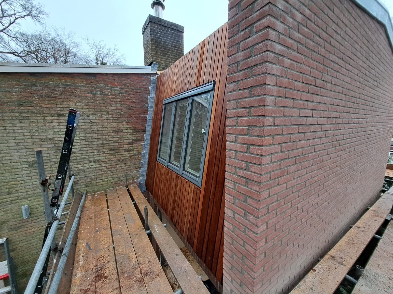 Opbouw met gevel van verticale houten delen en metselwerk, Bloemendaal